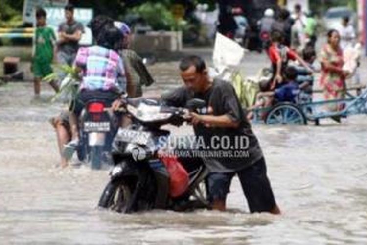 Sejumlah pengendara motor menembus banjir di Kawasan Sidokare, Sidoarjo, beberapa waktu lalu. 
