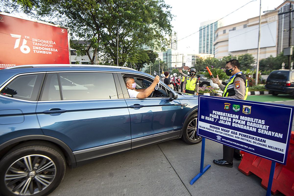 Anggota Polisi mengacungkan jempol pada pengendara mobil yang menunjukkan surat undangan vaksin COVID-19 di Gelora Bung Karno, Senayan saat berlangsungnya Pemberlakuan Pembatasan Kegiatan Masyarakat (PPKM) Darurat di kawasan Bundaran Senayan, Jakarta, Sabtu (3/7/2021). Petugas akan memberikan akses untuk melintas di titik penyekatan PPKM Darurat di 63 titik di wilayah Jadetabek yang berlaku dari 3 - 20 Juli 2021 hanya yang masuk kategori sektor-sektor esensial. ANTARA FOTO/M Risyal Hidayat/hp.