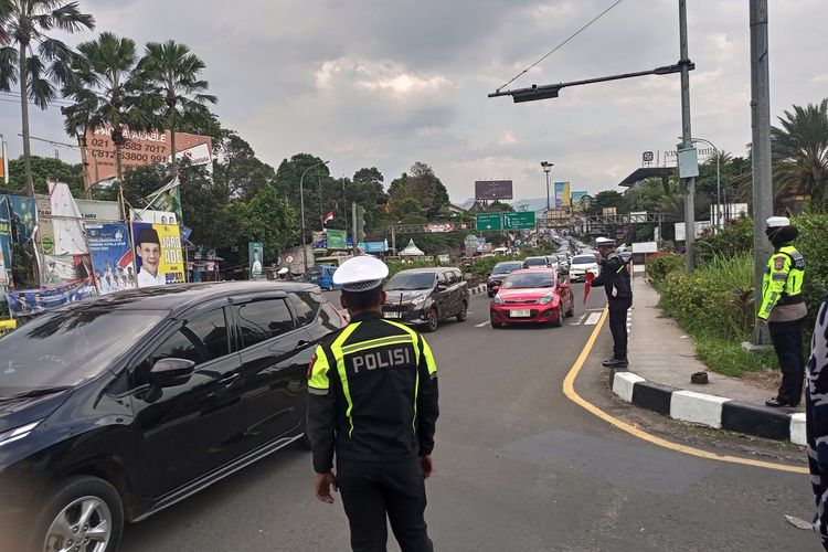 Polisi sedang membuka lajur dua arah di Jalur Puncak Bogor, Jawa Barat, Senin (16/9/2024).