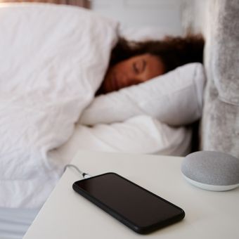 Ilustrasi ponsel atau handphone, Ilustrasi mengisi daya ponsel di meja sampi tempang tidur. 
