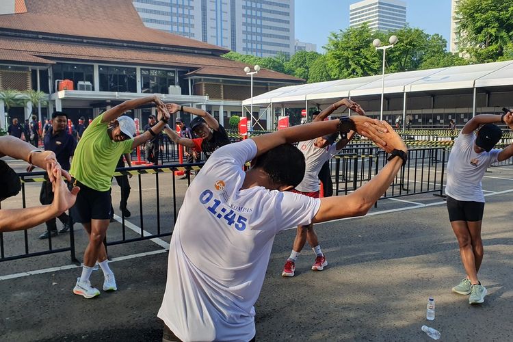 Para pelari dari berbagai komunitas melakukan pemanasan sebelum mengikuti acara Run The Ground with The Pacer sejauh 18 kilometer mengitari Jalan Sudirman-Thamrin, Minggu (18/6/2023). Ajang ini sebagai pemanasan jelang LPS Half Monas Marathon yang akan digelar pada 2 Juli 2023.