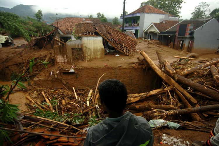 Seorang warga memperhatikan permukiman yang terkena banjir material longsor di Desa Pasirpanjang, Salem, Brebes, Jawa Tengah, Jumat (23/2/2018). Puluhan rumah hancur dan penuh lumpur akibat terkena material longsor bukit Gunung Lio.