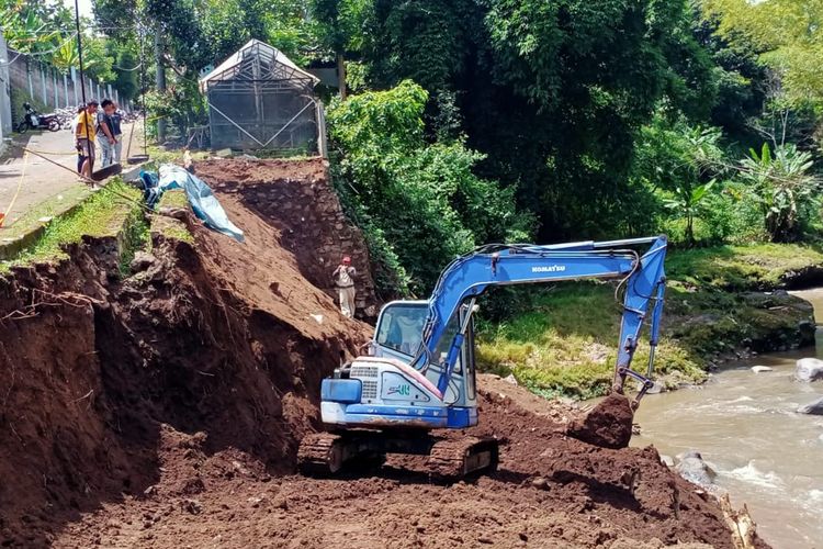 Alat berat sedang membuat galian untuk pondasi dalam pembangunan plengsengan yang ambrol di perumahan Sengkaling Residence yang berada di Jalan Ir Soekarno, Kota Batu.