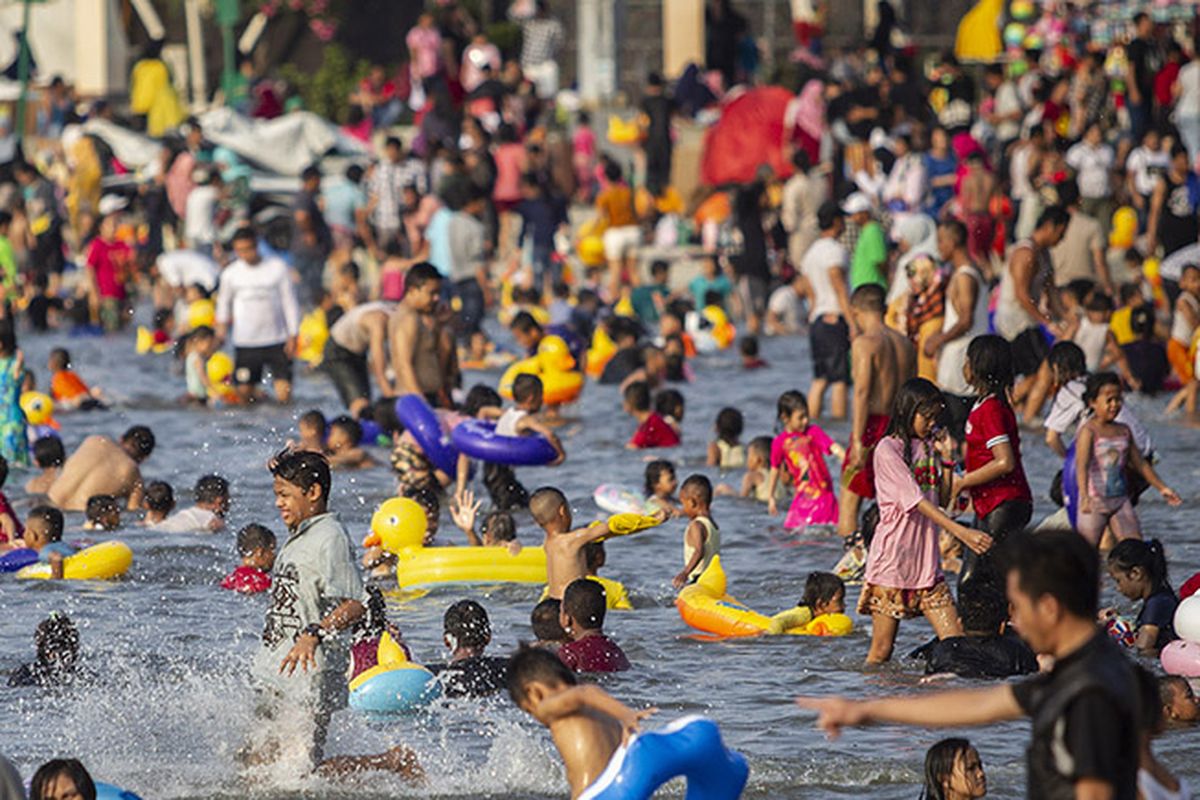 Pengunjung bermain air di Pantai Karnaval Ancol, Jakarta, Kamis (6/6/2019). Hingga sore ini tercatat sekitar 100 ribu pengunjung memanfaatkan waktu libur Lebaran 2019 bersama keluarga di Taman Impian Jaya Ancol.