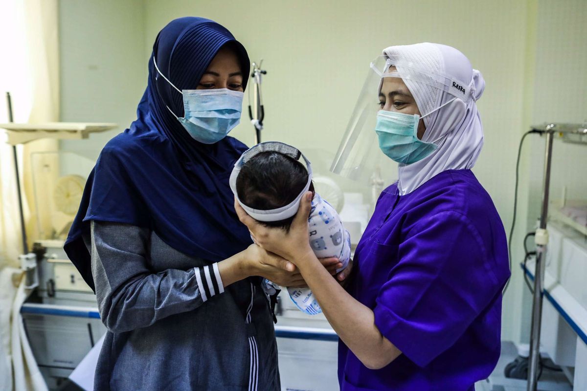 Perawat merawat bayi yang baru lahir di ruangan Perina di Rumah Sakit Ibu dan Anak (RSIA) Tambak, Jakarta Pusat, Sabtu (23/5/2020). Rumah Sakit Ibu dan Anak (RSIA) menerapkan kebijakan baru berupa pemakaian face shield atau pelindung wajah untuk bayi yang sedang mendapat perawatan maupun yang baru dilahirkan di RS tersebut. Hal tersebut dilakukan untuk mencegah terjadinya penularan virus corona jenis baru atau SARS-CoV-2 yang menyebabkan penyakit Covid-19.