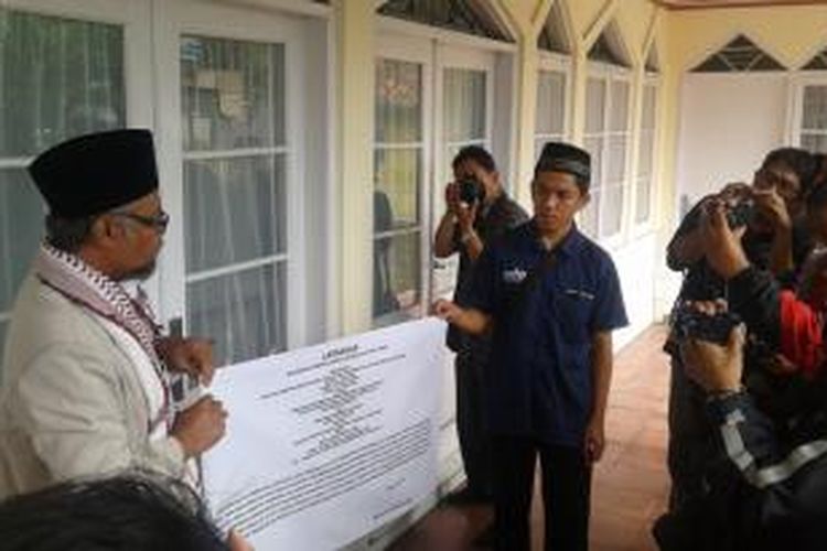 Mubaligh Ahmadiayah Ciamis Muhammad Syaiful Uyun, Jumat (4/7/2014), membuka banner segel di Masjid Nur Khilafat, Ciamis, Jawa Barat. Penyegelan oleh Satpol PP sebelumnya dilakukan pada Kamis (26/6/2014).