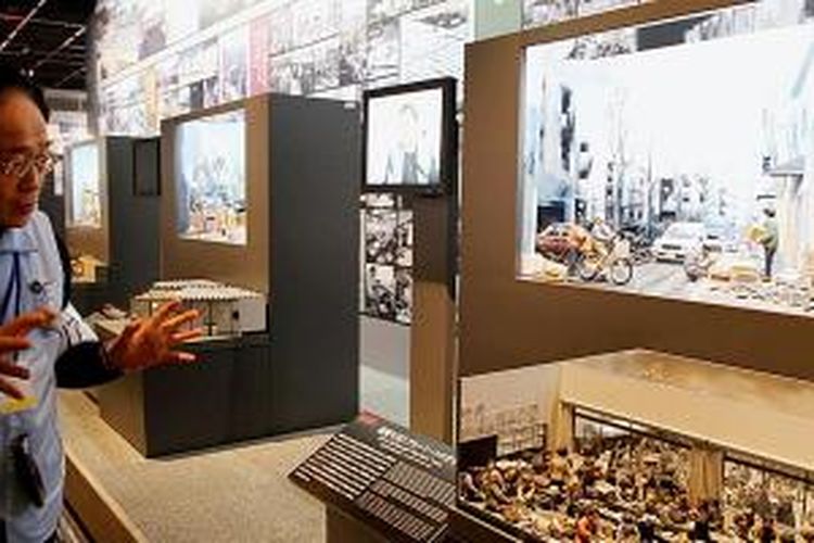 Koichi Yunoki, relawan di Museum Pengurangan Bencana Kobe, Jepang, menjelaskan proses rekonstruksi setelah gempa yang melanda Kobe tahun 1985, Jumat (16/1/2015). Museum yang didesain modern dan tertata apik itu menjadi wahana pengingat tragedi, sekaligus pembelajaran tentang kesiapsiagaan kepada masyarakat.