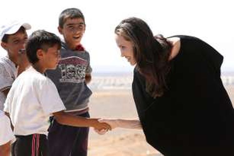 Aktris AS yang menjadi utusan khusus PBB Angeline Jolie berbicara dengan seorang anak di kamp pengungsi Suriah di Azraq, Jordania, Jumat (9/9/2016).
