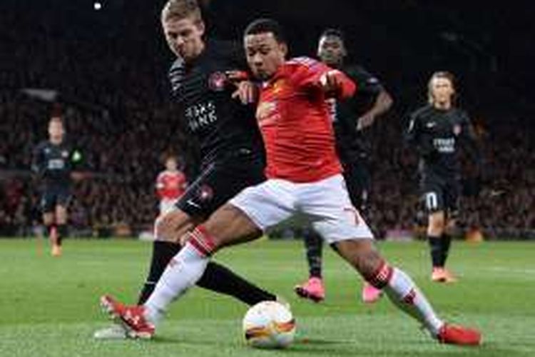 Bek Midtjylland, Andre Romer (kiri), berduel dengan pemain Manchester United, Memphis Depay, pada laga kedua babak 32 besar Liga Europa di Stadion Old Trafford, Kamis (25/2/2016) atau Jumat dini hari WIB.