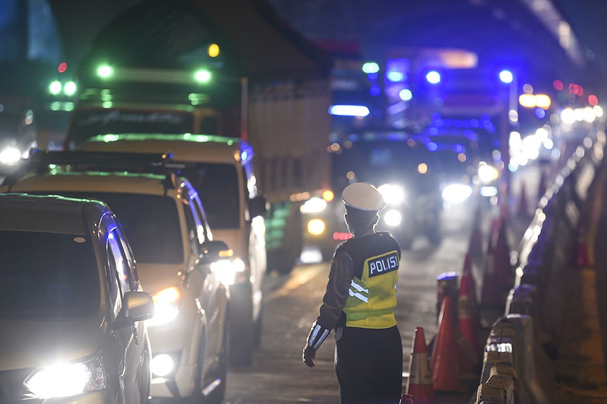 Petugas kepolisian mengarahkan kendaraan pribadi yang melintas di tol Jakarta-Cikampek untuk keluar melalui pintu tol Cikarang Barat 3, Jawa Barat, Kamis (21/5/2020). Pengalihan tersebut sebagai upaya penyekatan gelombang pemudik jelang perayaan Hari Raya Idul Fitri 1441 H dari arah Jakarta menuju Jawa Tengah.
