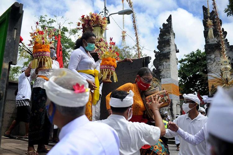Warga membawa sejumlah sesaji saat perayaan Hari Raya Kuningan di Pura Sakenan di Pulau Serangan, Bali, Sabtu (26/9/2020). Hari Raya Kuningan yang digelar beberapa hari setelah Galungan ini dimaksudkan untuk merayakan saat Dewa-dewa dan leluhur kembali ke surga setelah bertemu keturunannya.