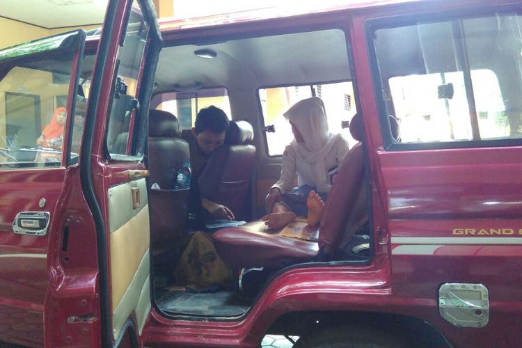 Fatmawati, siswi SMK Negeri 2 Mataram tengah bersiap-siap mengikuti UNBK di dalam mobil.