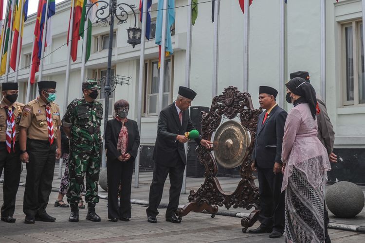 Dirjen Informasi dan Diplomasi Publik Kementerian Luar Negeri Teguh Wardoyo (tengah) didampingi Wakil Gubernur Jawa Barat Uu Ruzhanul Ulum memukul gong sebagai tanda pembukaan rangkaian peringatan 67 tahun Konferensi Asia Afrika (KAA) saat upacara pengibaran bendera peserta KAA di Jalan Sukarno, Bandung, Jawa Barat, Senin (18/4/2022).