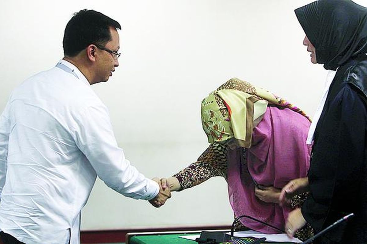 Terdakwa kasus dugaan suap dana penyesuaian infrastruktur daerah, Wa Ode Nurhayati (tengah), menyalami Wakil Ketua Fraksi PAN Andi Anzhar Cakra Wijaya (kiri) di Pengadilan Tindak Pidana Korupsi Jakarta, Selasa (18/9). Kemarin, Andi Anzhar menjadi saksi meringankan dalam persidangan Wa Ode.