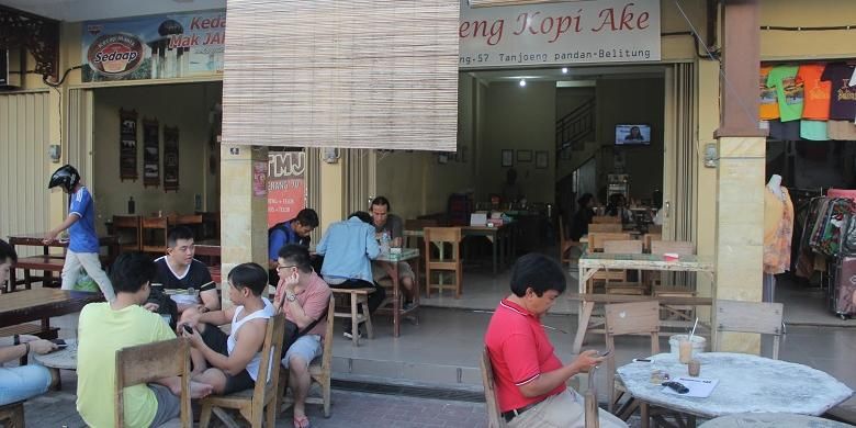 Penikmat kopi tengah berbincang di depan Warung Kopi Ake, Belitung, Senin (7/3/2016) sore.