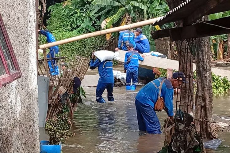 Petugas SDA berusaha menutupi tembok dengan karung pasir di samping Mushala Sabili, Jati Padang, Pasar Minggu, Jakarta Selatan yang jebol, Jumat (31/10/2025).