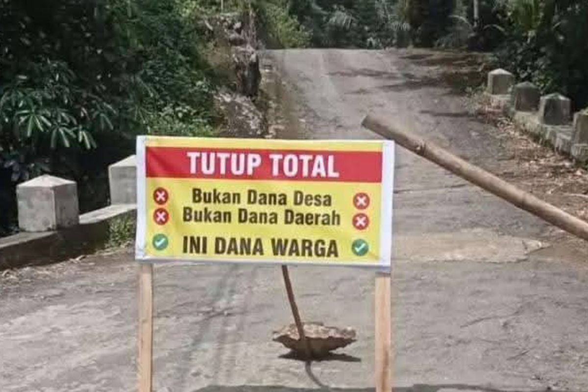 WARGA SWADAYA MANDIRI - Selama proses perbaikan, jalan hasil swadaya masyarakat di Desa Ngadimulyo Kecamatan Kampak Kabupaten Trenggalek Jawa Timur, ditutup dengan papan tulisan, Selasa (11/03/2025).