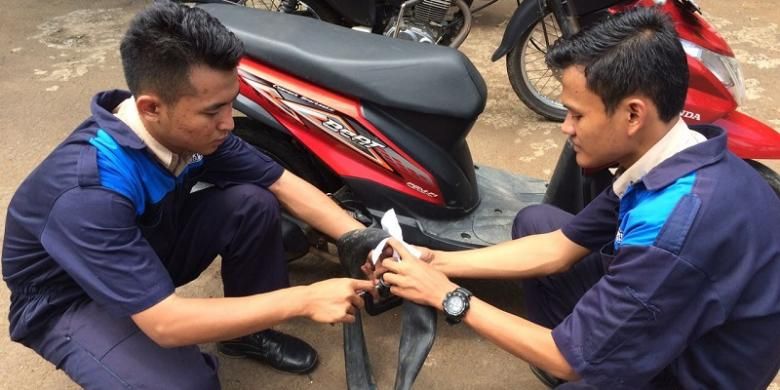 Dua siswa SMK N 1 Kedungwuni, Pekalongan, Jawa Tengah, mempraktekkan cara kerja tambal ban portabel yang menjadi temuannya. 