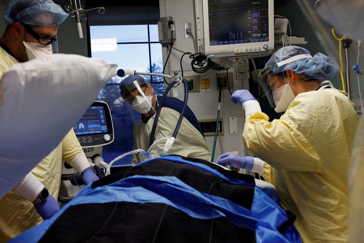 Staf medis merawat pasien Covid-10 di ruang isolasi mereka di Unit Perawatan Intensif (ICU) di Rumah Sakit Western Reserve di Air Terjun Cuyahoga, Ohio, AS, Selasa (4/1/2022). 