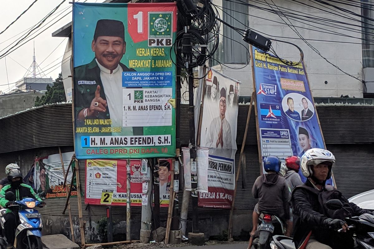 Sejumlah alat peraga kampanye (APK) masih terpasang di Kelapa Dua, Kebon Jeruk, Jakarta Barat, Senin (15/4/2019).
