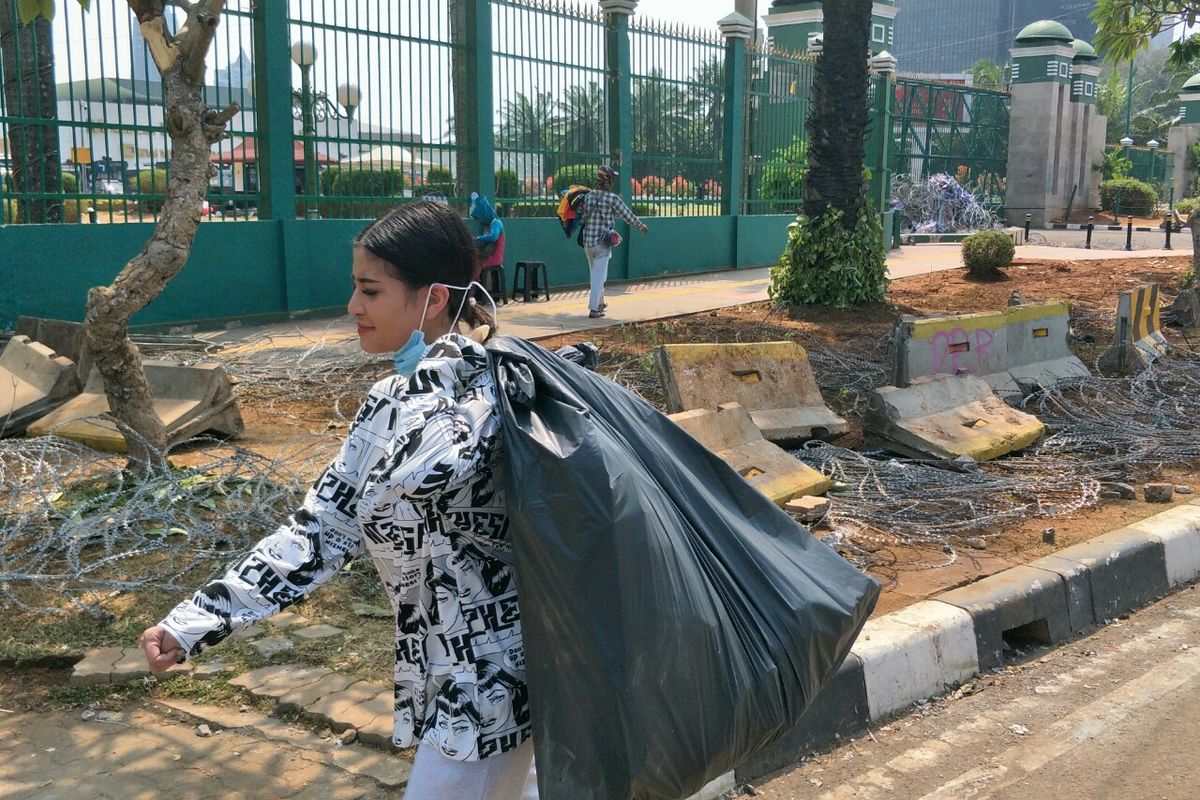 Selebgram Awkarin membawa kantong plastik berisikan sampah di depan gedung DPR Ri,