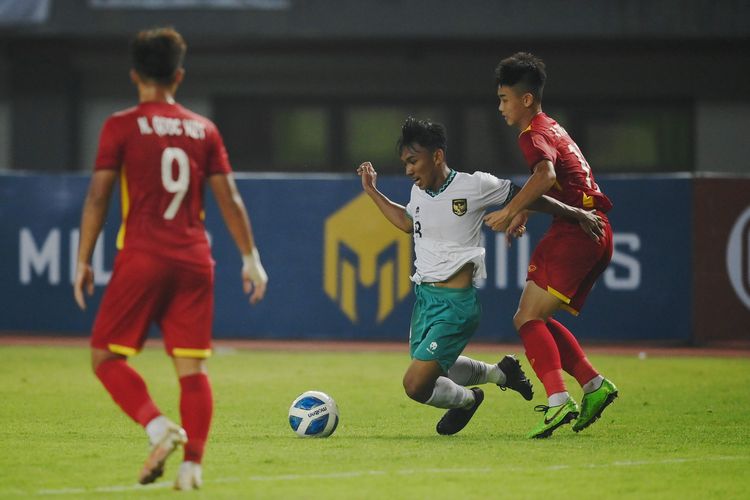 Pesepak bola Tim Nasional Indonesia U-19 Arkhan Fikri (tengah) terjatuh saat berebut bola dengan pesepak bola Tim Nasional Vietnam U-19 dalam laga penyisihan Grup A Piala AFF U-19 2022 di Stadion Patriot Candrabhaga, Bekasi, Jawa Barat, Sabtu (2/7/2022). ANTARA FOTO/Aditya Pradana Putra/rwa.