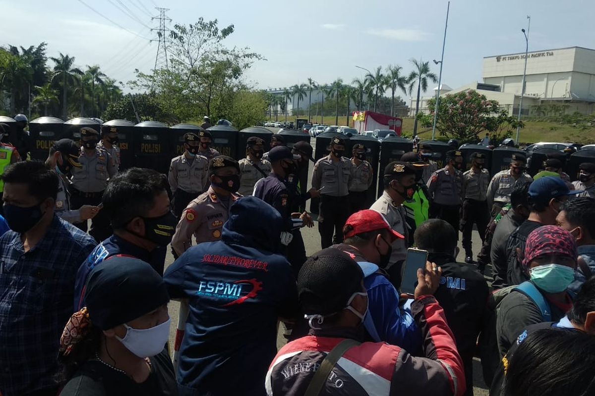 Puluhan personel kepolisian menyekat jalan di salah satu kawasan industri di Kabupaten Bekasi, Jawa Barat, yang menjadi rute buruh menuju DPR RI.