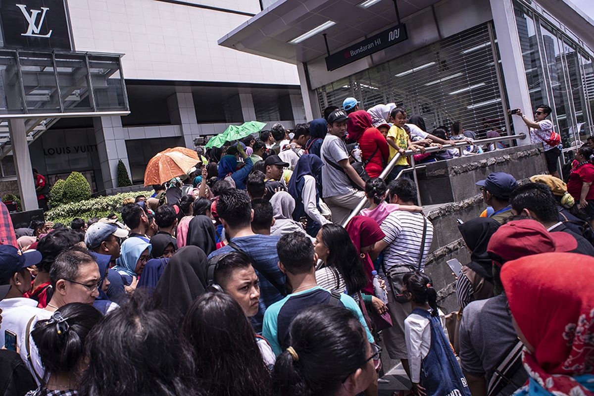 Warga mengantri untuk menaiki kereta MRT di pintu masuk Stasiun MRT Bundaran HI, Jakarta, Minggu (24/3/2019). Moda Raya Terpadu (MRT) Jakarta Fase 1 dengan rute Bundaran HI - Lebak Bulus resmi beroperasi sejak diresmikan oleh Presiden Jokowi, Minggu hari ini.