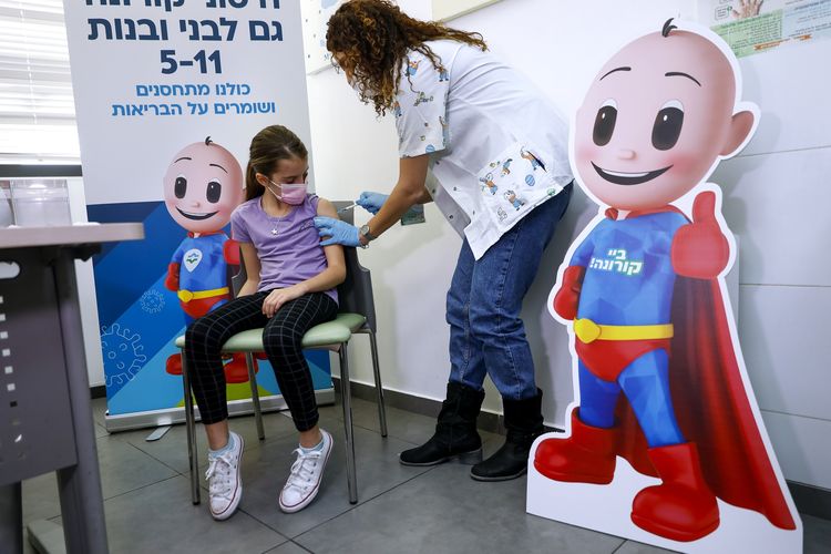 Danae Vitkin (9) disuntik dosis pertama vaksin Covid-19 Pfizer di Clalit Health, Tel Aviv, Israel, Selasa (23/11/2021). Israel mulai hari itu memvaksinasi anak-anak usia 5-11 tahun.