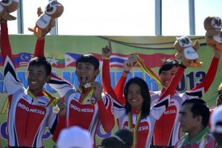 Timnas balap sepeda Indonesia (dari kiri) Bandi Sugito, Chandra Rafsanzani, Kusmawati Yazid dan Wilhelmina Tutuarima memamerkan medali emas usai mengikuti upacara pengalungan medali Cross Country Team Relay SEA Games 2013 di Mount Pleasant, Naypyitaw, Myanmar, Kamis (12/12/2013). Dalam ajang tersebut, team balap sepeda Indonesia tampil sebagai yang tercepat dan berhak membawa pulang empat medali emas.