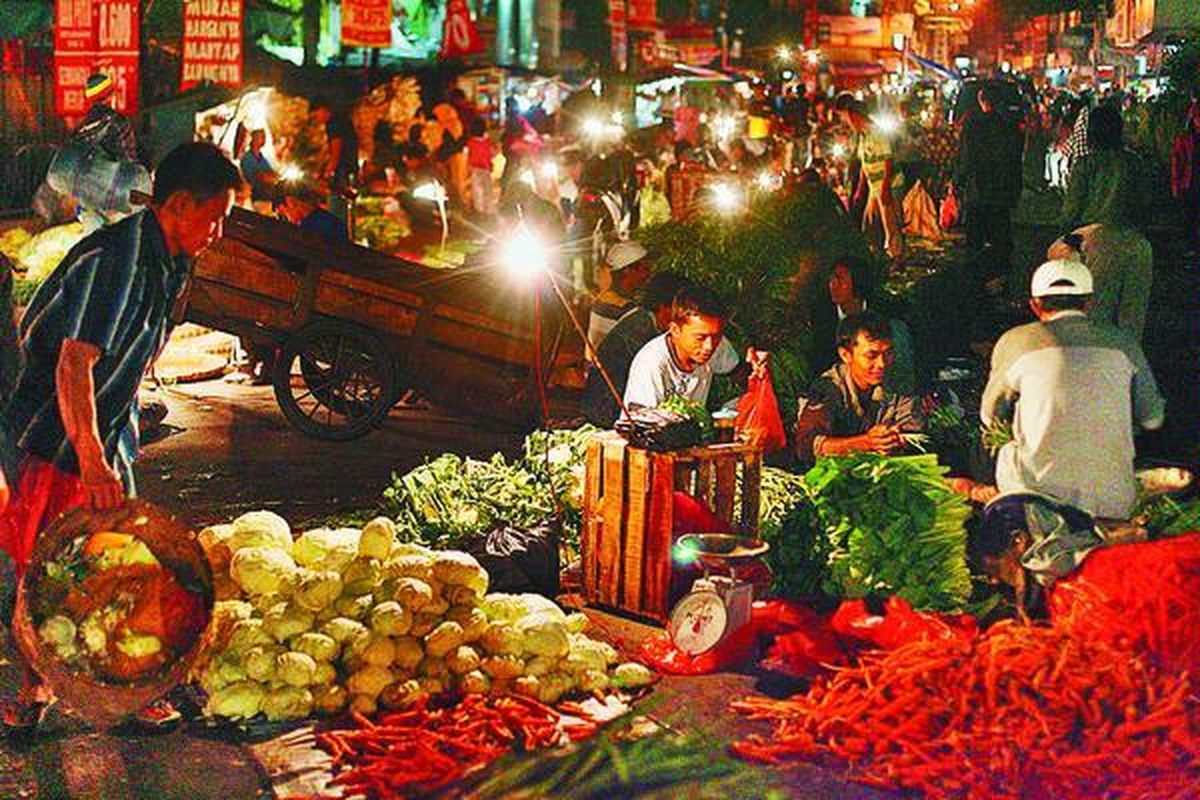 Pedagang menata dagangannya di hingga ke badan jalan