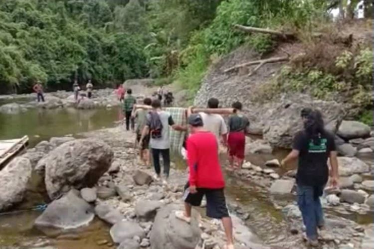 Demi berobat, warga bernama Dekke harus ditandu menempuh jarak belasan km, menyusuri sungai dan bukit, menuju puskesmas di kota kecamatan di Polewali Mandar, Rabu (13/11/2019). 