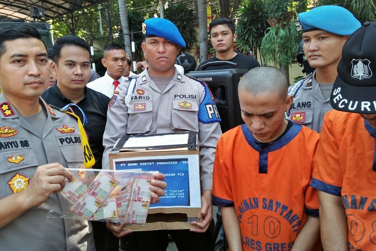 Kapolres Gresik AKBP Wahyu Sri Bintoro (kiri), saat menunjukkan barang bukti uang tunai hasil kejahatan pelaku (kanan).