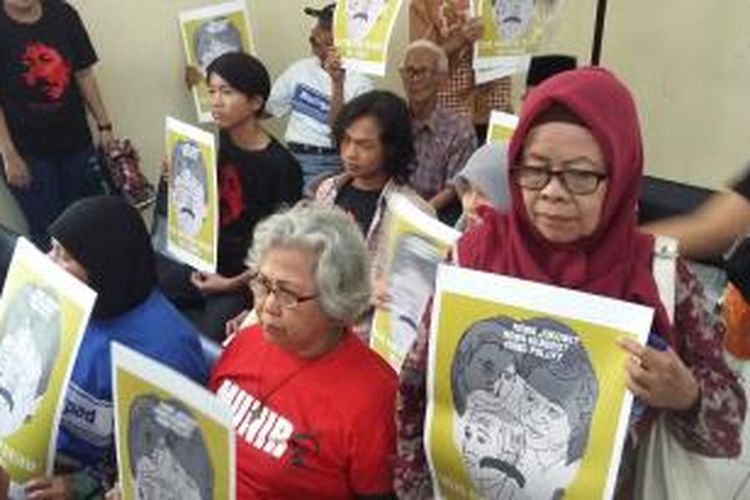 Para pegiat HAM menggunakan poster bergambar wajah aktivis HAM Munir Said Thalib, saat persidangan di Pengadilan Tata Usaha Negara (PTUN) Jakarta, Rabu (29/7/2015).