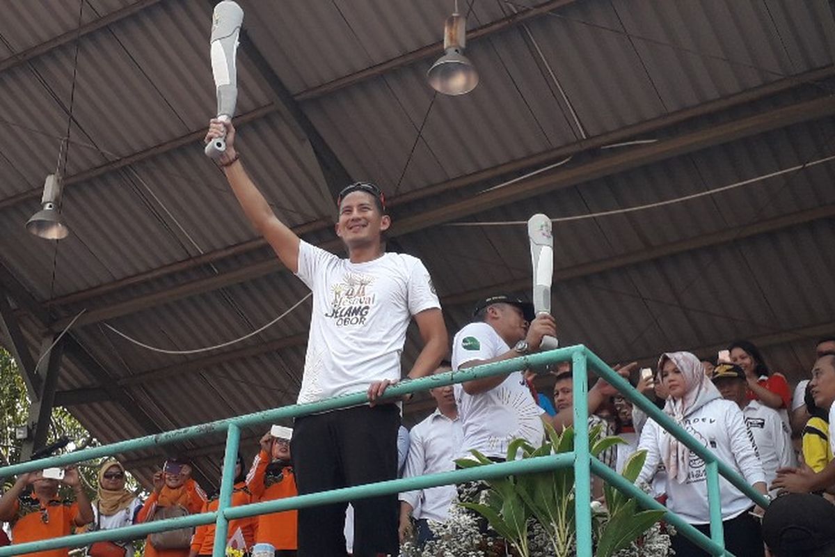 Wakil Gubernur DKI Jakarta Sandiaga Uno membawa replika obor Asian Games 2018 di Lapangan Kemayoran, Jakarta Pusat pada Minggu (8/7/2018).