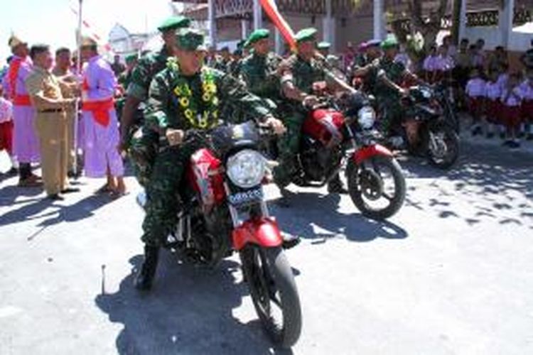 Pangdam VII/Wirabuana, Mayjen TNI Bachtiar (berkalung bunga) mengendarai sepeda motor ketika melakukan kunjungan kerja di Pulau Minagas, Kabupaten Kepulauan Talaud.