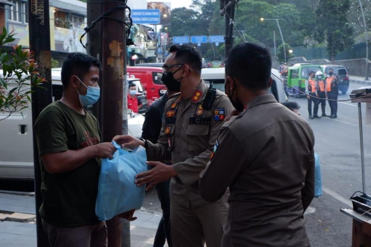 Kepala Satpol PP Kota Bogor Agustian Syach saat memberikan bantuan sembako kepada salah satu pedagang yang terdampak PPKM darurat.