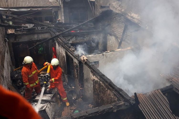 Petugas pemadam kebakaran berupaya memadamkan api di sebuah rumah tinggal yang terbakar di kawasan Sunter Agung, Kamis (4/10/2018).