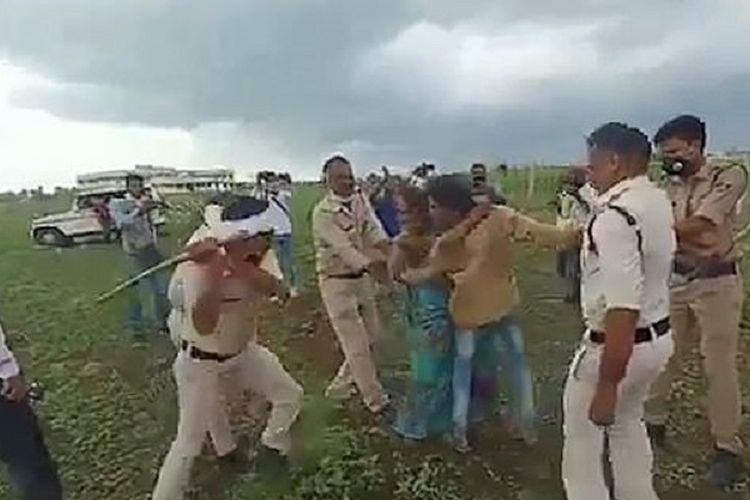Salah seorang polisi mengayunkan tongkat pemukul kepada pasangan dari Dalit, kasta rendah India, dalam insiden yang berlangsung di Madhya Pradesh. Pasangan itu disebut berupaya bunuh diri setelah dipukuli dan panen mereka dihancurkan.