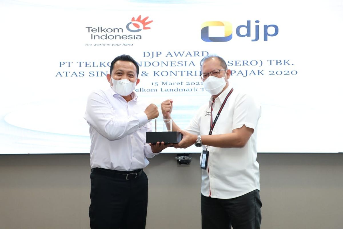 Direktur Keuangan Telkom Heri Supriadi (kanan) menyerahkan cindera mata kepada Kepala KPP Wajib Pajak Besar Empat Budi Prasetya saat acara penyerahan apresiasi kepada PT Telkom Indonesia (Persero) Tbk (Telkom) atas sinergi dan kontribusi pajak di tahun 2020 di Jakarta, Senin (15/3/2021).
