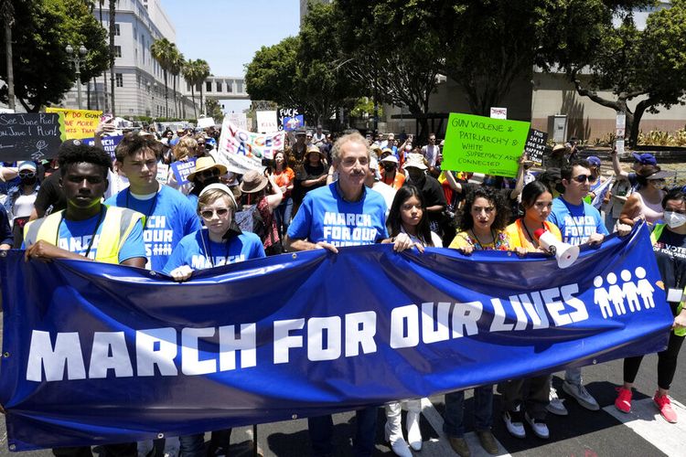 Pengacara Kota Los Angeles dan mantan calon walikota Mike Feuer, tengah, berbaris bersama dengan pemrotes saat mereka meneriakkan dan melambaikan tanda di pusat kota Los Angles selama demonstrasi March for Our Lives, Sabtu, 11 Juni 2022. 