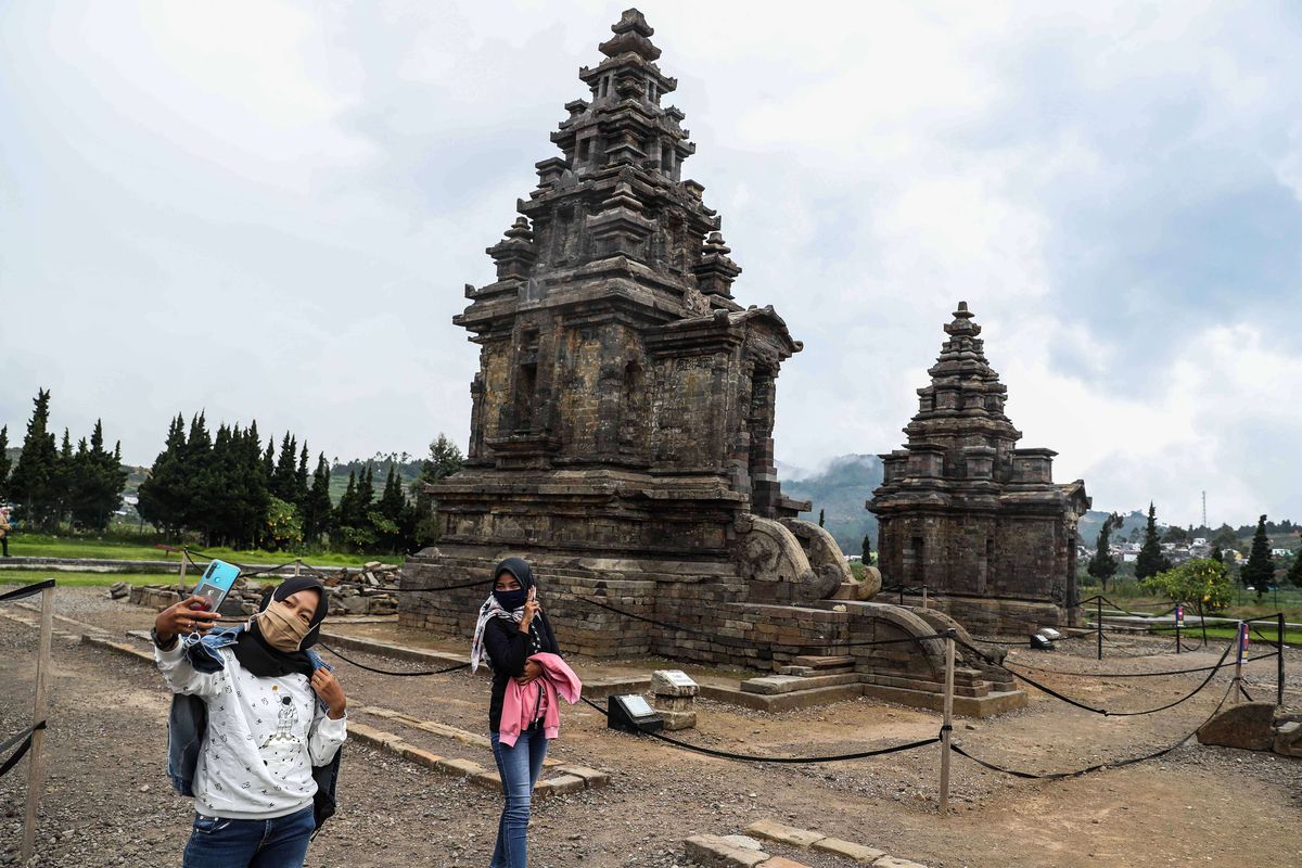 Wisatawan saat berada di Candi Arjuna, salah-satu candi di kompleks candi Dieng, Kabupaten Banjarnegara, Jawa Tengah, Minggu (15/10/2020).