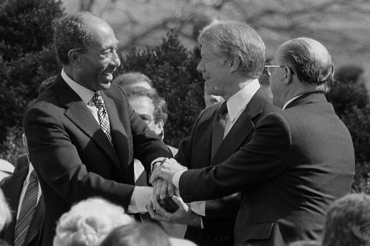 El presidente egipcio Anwar Sadat, el presidente estadounidense Jimmy Carter y el primer ministro israelí Menachem Begin se dan la mano después de firmar un acuerdo de paz en la Casa Blanca, Washington DC.