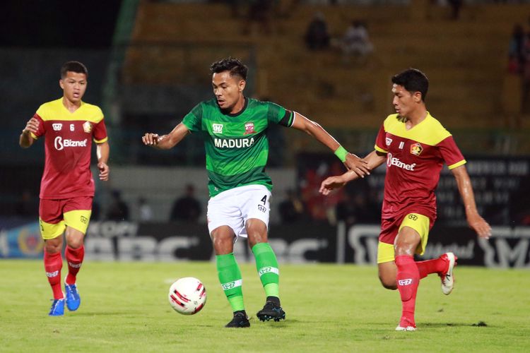 Pemain Madura United Asep Berlian dijaga ketat pemain Persik Kediri dalam lanjutan babak penyisihan grup A Piala Gubernur Jatim 2020 yang berakhir dengan skor 0-1 di Stadion Gelora Bangkalan, Jawa Timur, Rabu (12/02/2020) malam.