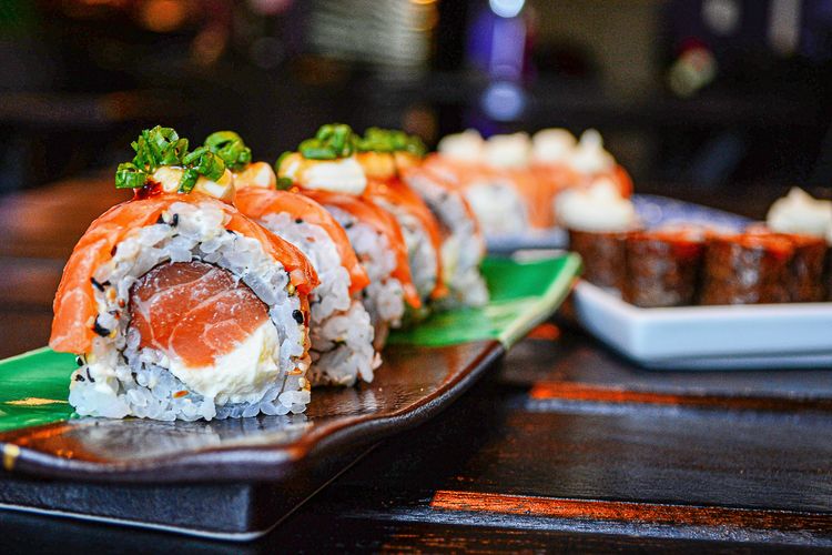 Ilustrasi sushi roll dengan isian ikan mentah.