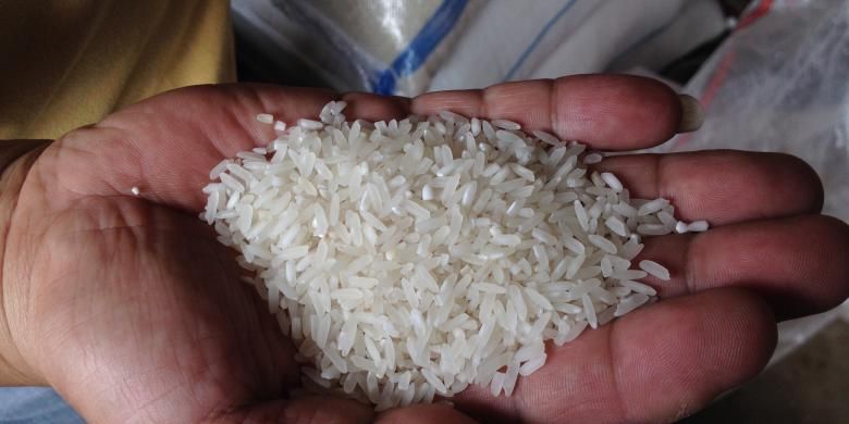 Pedagang beras di Pasar Induk Tanah Tinggi, Tangerang, menunjukkan contoh beras yang sebenarnya, Kamis (21/5/2015) pagi. 