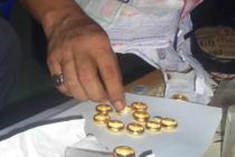 Pedagang memperlihatkan cincin emas yang laku keras sejak harga emas turun. (DESI)