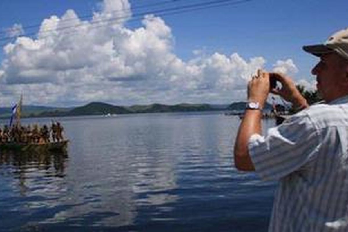 Turis asing mengabadikan Tari Perang di Festival Danau Sentani, Jayapura, Papua, Selasa (19/6/2012).
