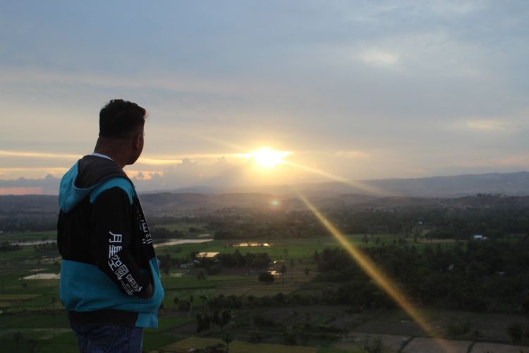 Seorang pengunjung sedang menikmati keindahan sunset di Bukit Persaudaraan.