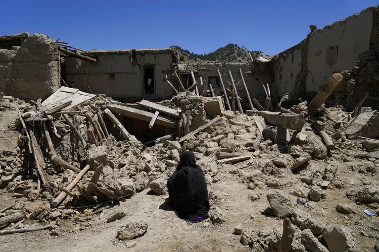 Wanita Afghanistan duduk di tengah kehancuran setelah gempa bumi di desa Gayan, di provinsi Paktika, Afghanistan, Jumat 24 Juni 2022.